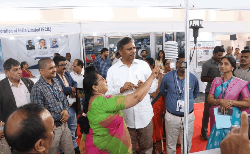 Guests examining a meteorological instrument at the Bharat Pride expo