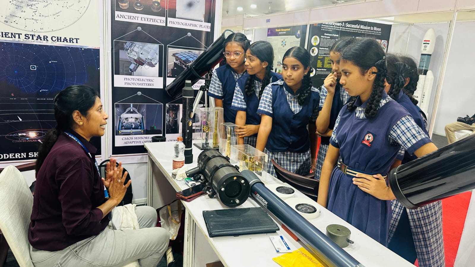 School students exploring astronomy equipment at a Bharat Pride exhibition stall
