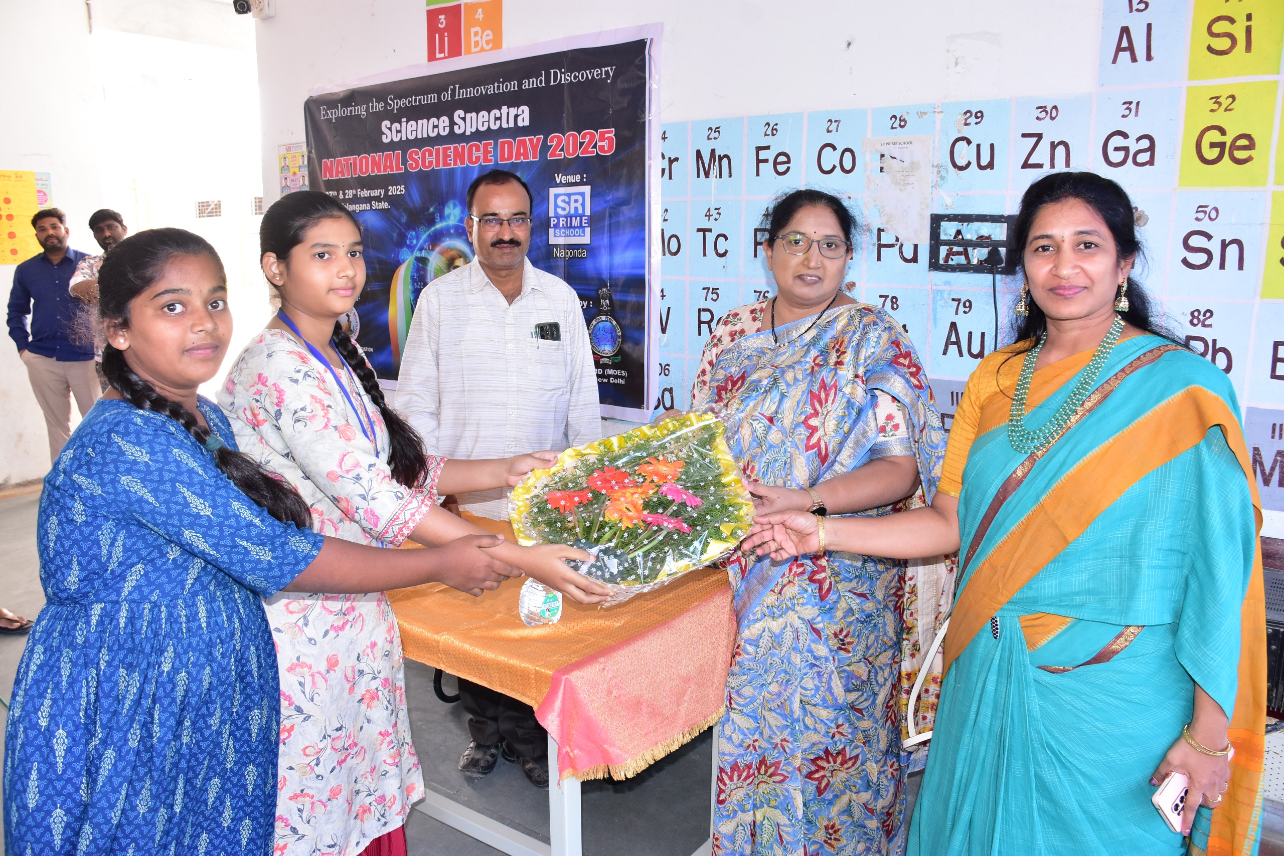 Students presenting a bouquet to National Science Day guests